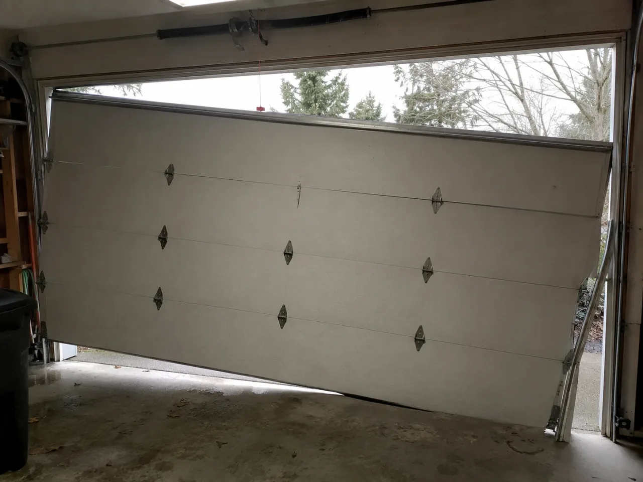 Garage door off its track on a Des Moines, WA home before Boost Garage Doors repaired it.