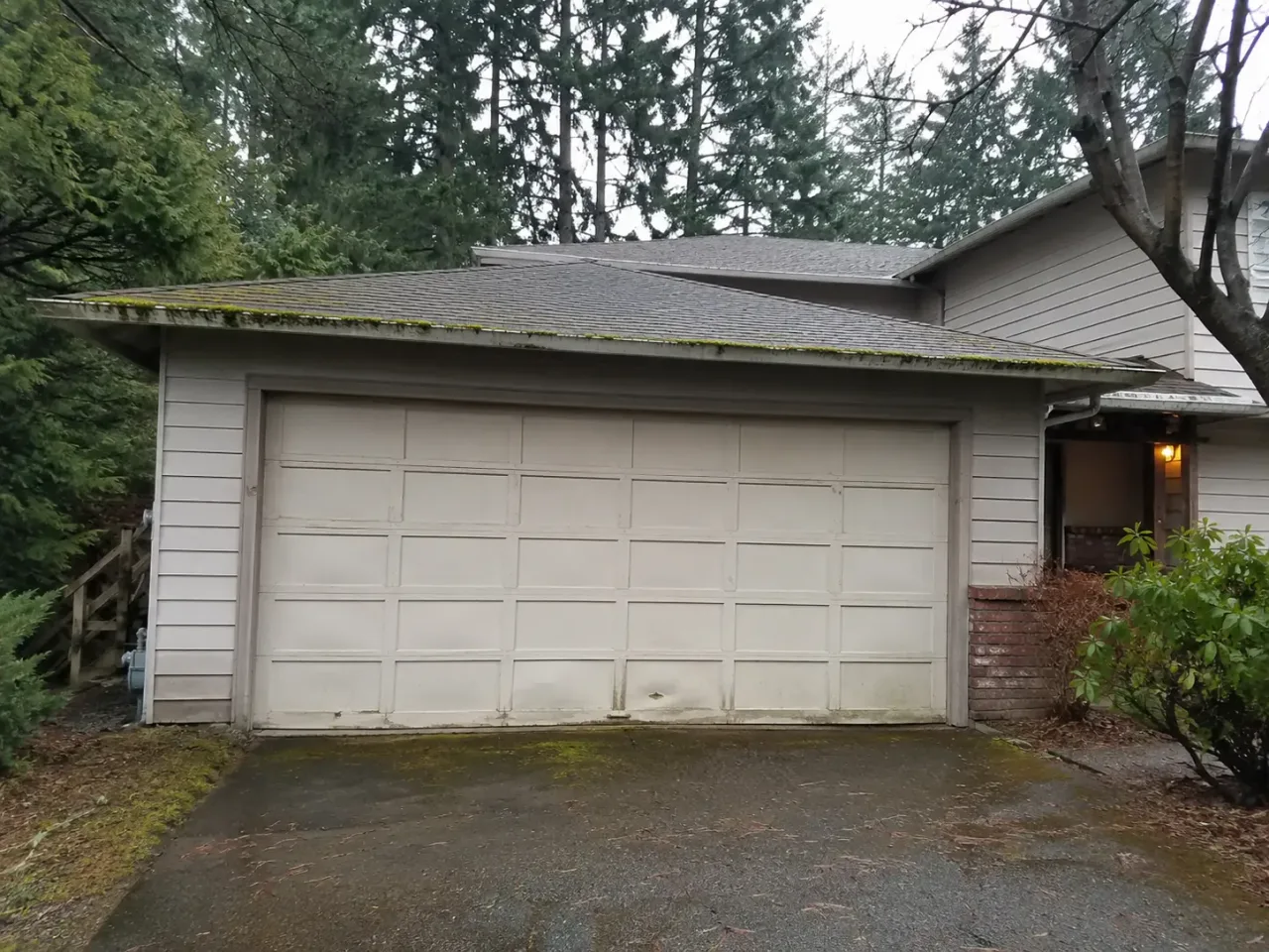 Old, worn garage door on a Renton, WA home before Boost Garage Doors replaced it.