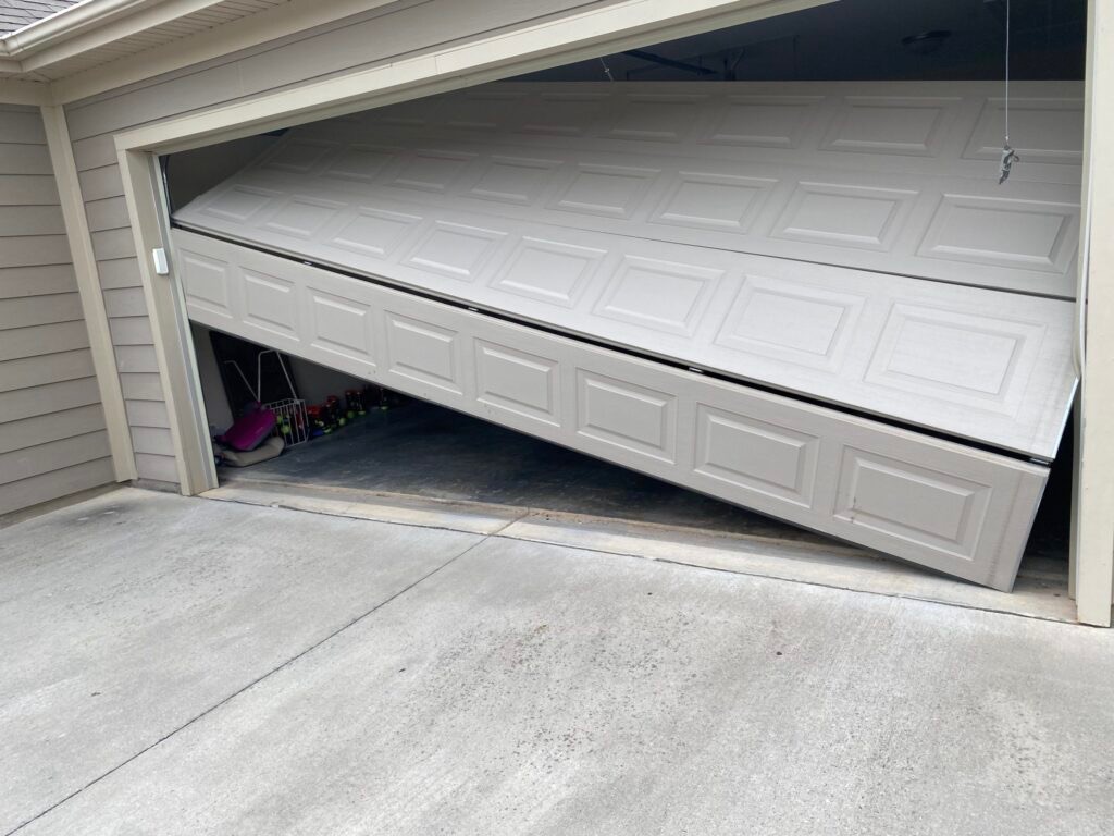 Garage door hanging crooked after a snapped lift cable.