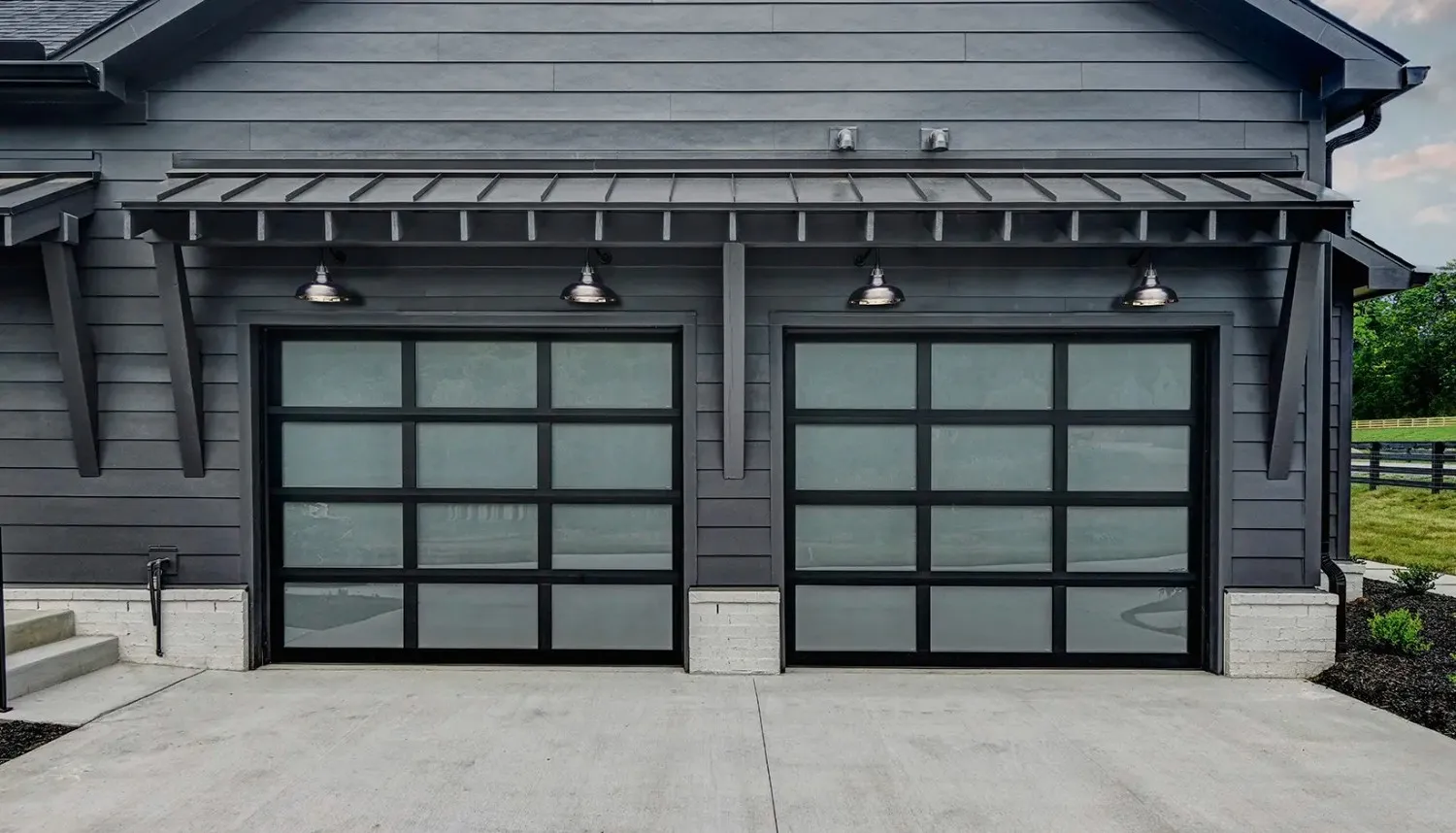 New glass and black double garage door on a modern home exterior.