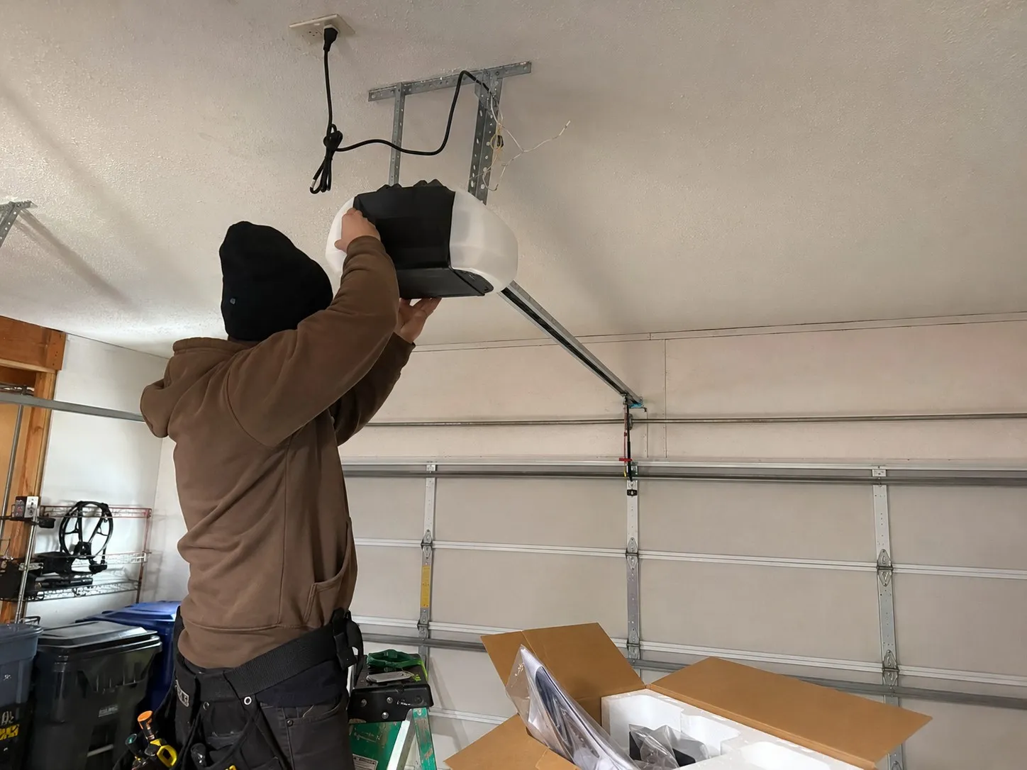 Newly installed garage door opener unit mounted to the ceiling.