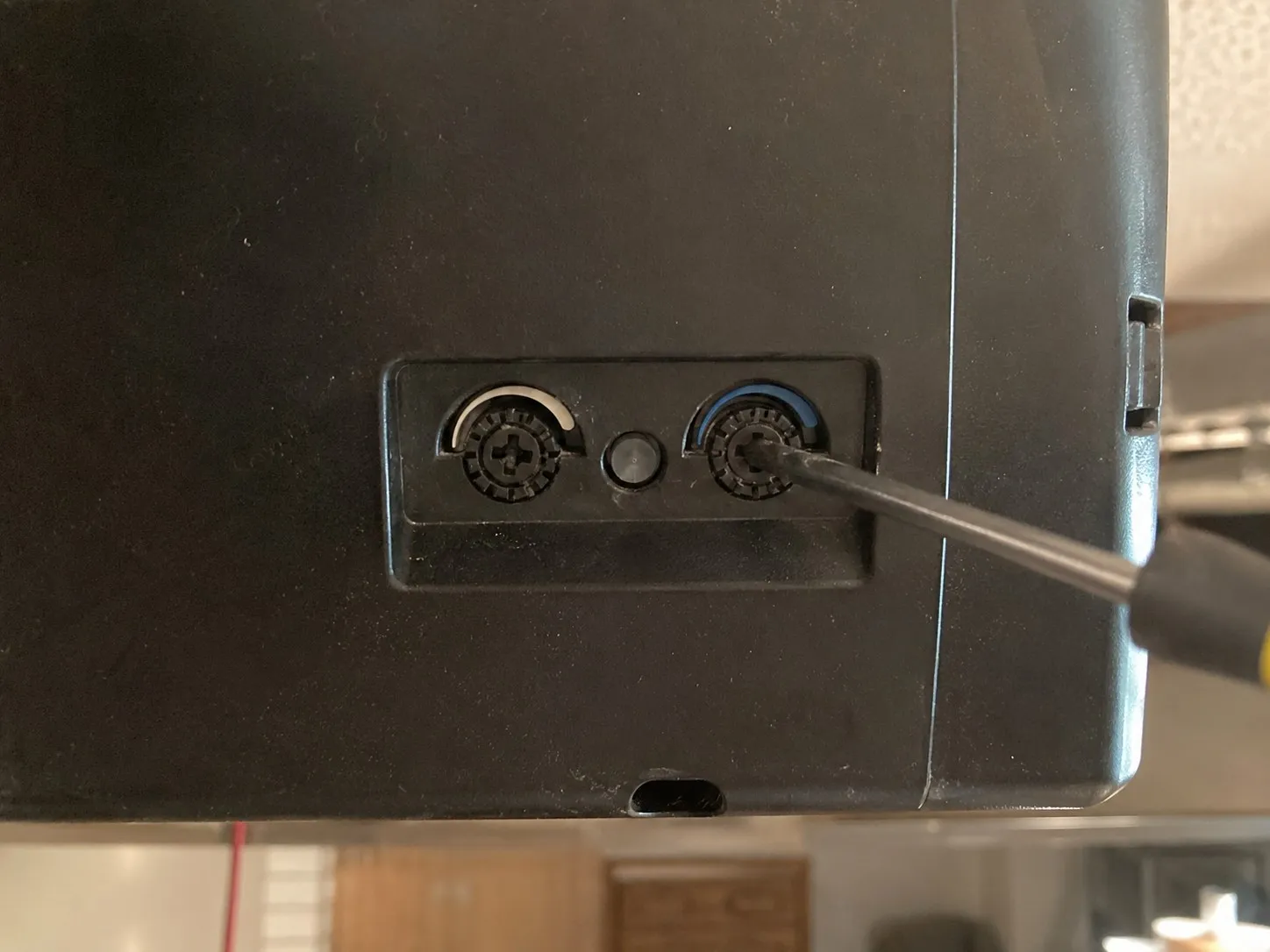 Adjusting the closing force setting on a garage door opener during a tune-up.