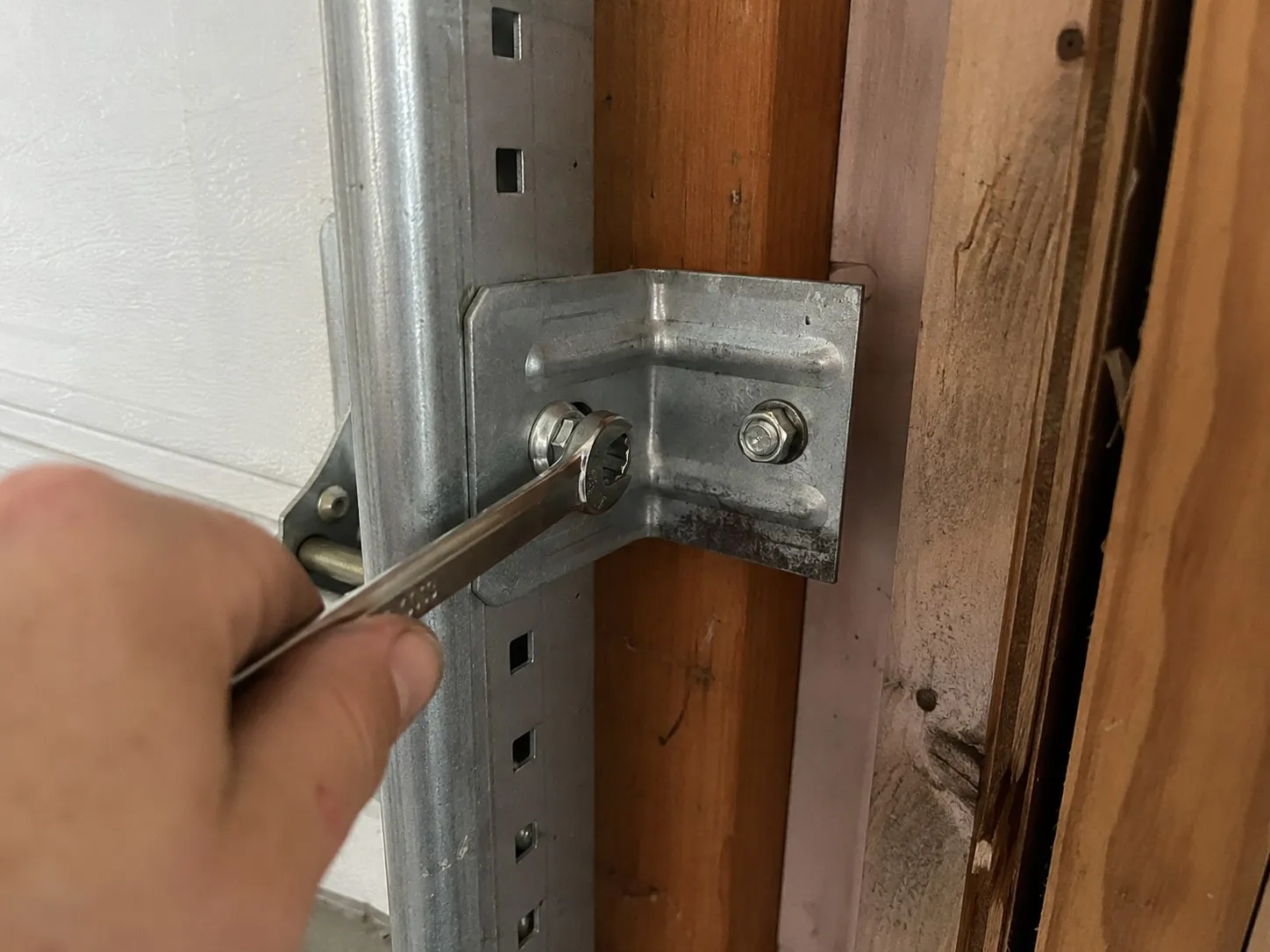 Garage door track bracket bolted to the garage wall.