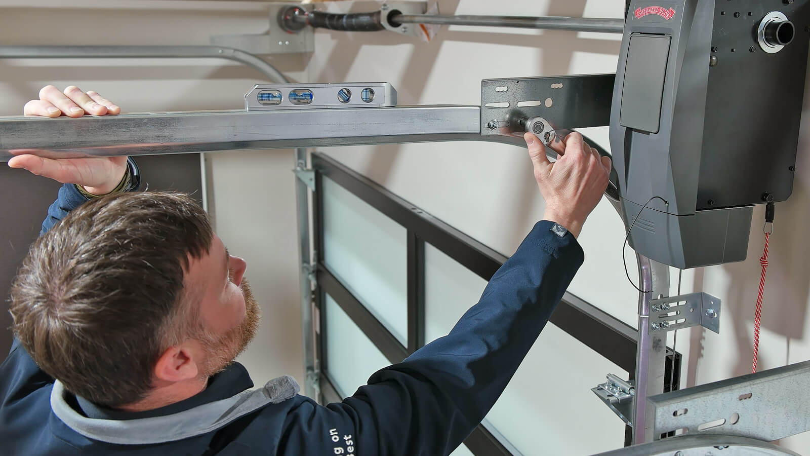 Garage door opener rail and drive being aligned during a repair.