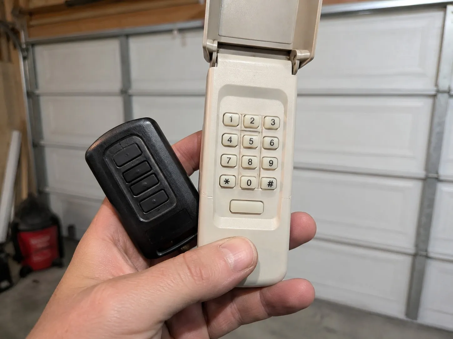 Garage door remote and wall keypad being programmed.
