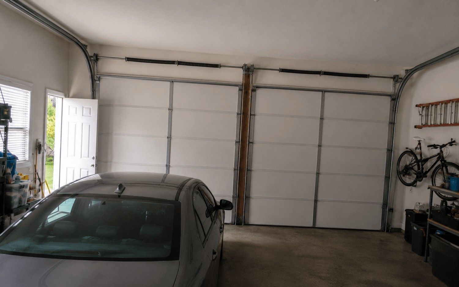 The same garage with a new spring on the bar and both doors balanced again, repaired by Boost Garage Doors.
