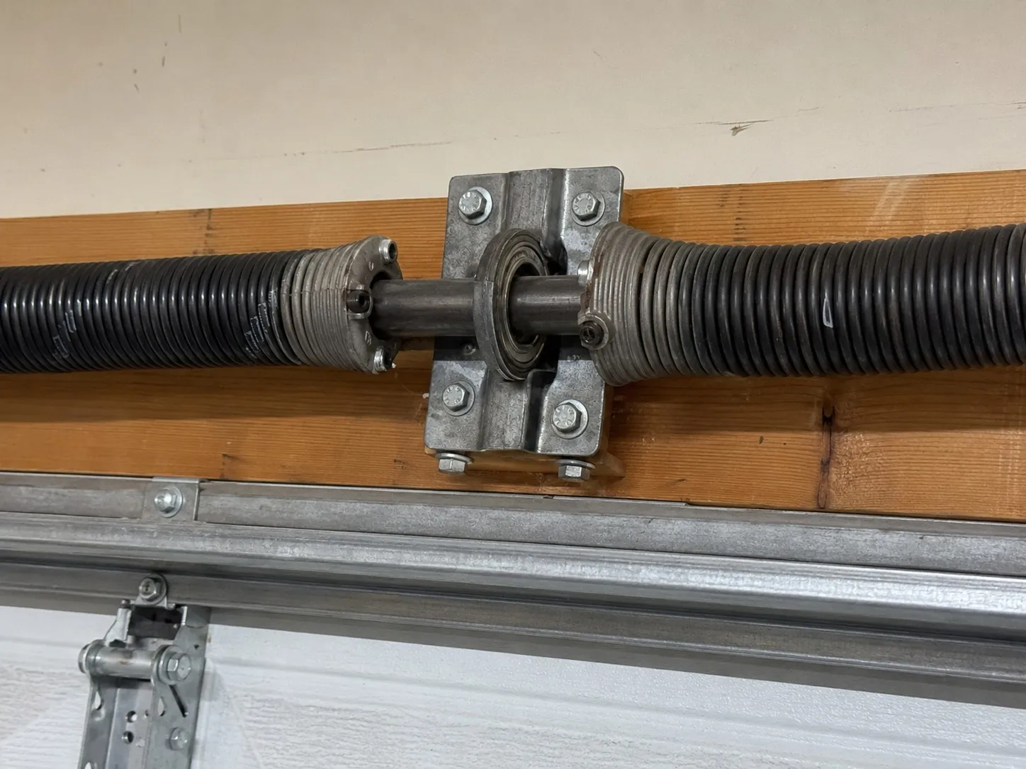 Center bearing bracket supporting a garage door torsion shaft.