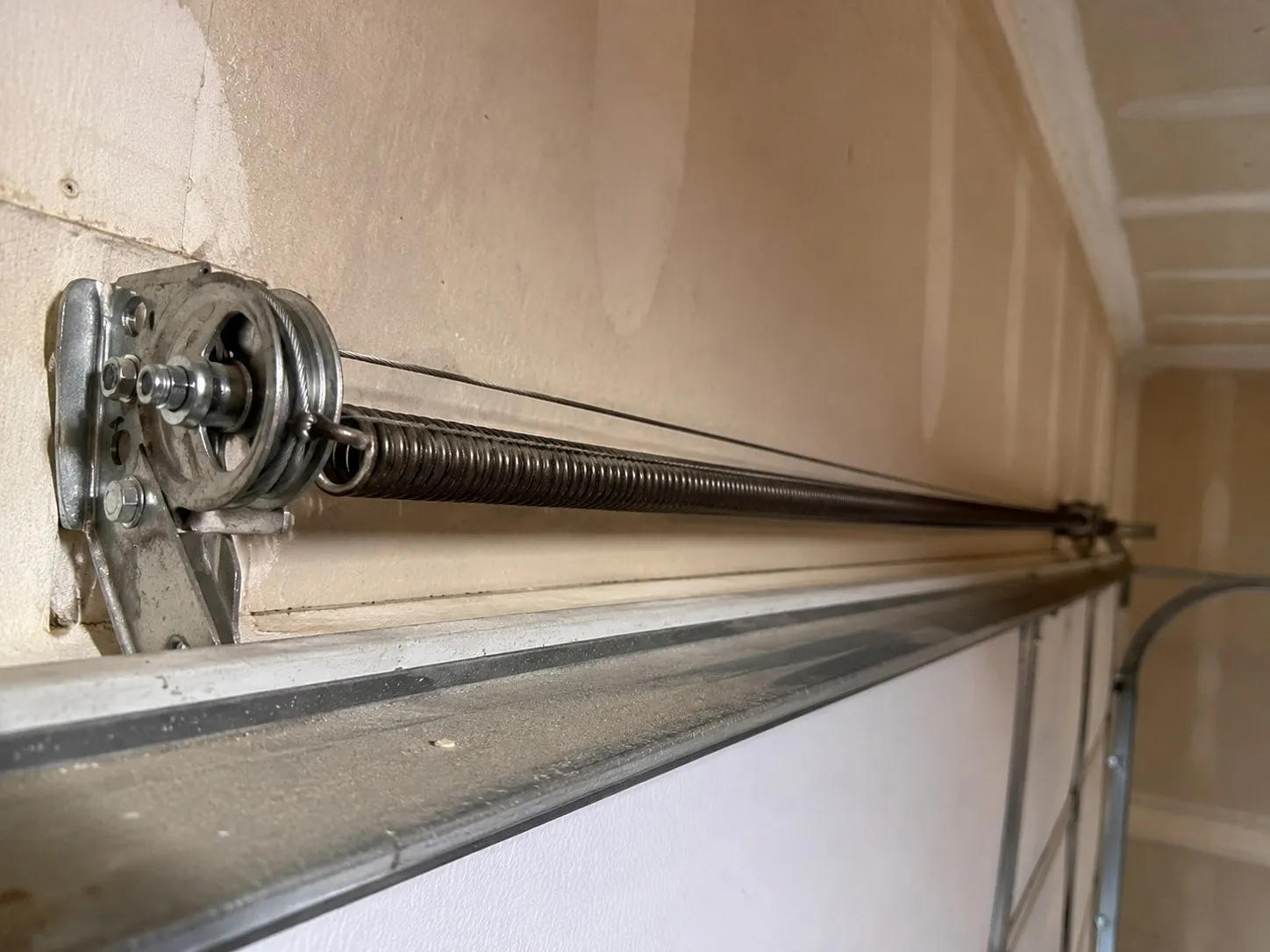 Extension spring mounted along the horizontal track of a garage door.