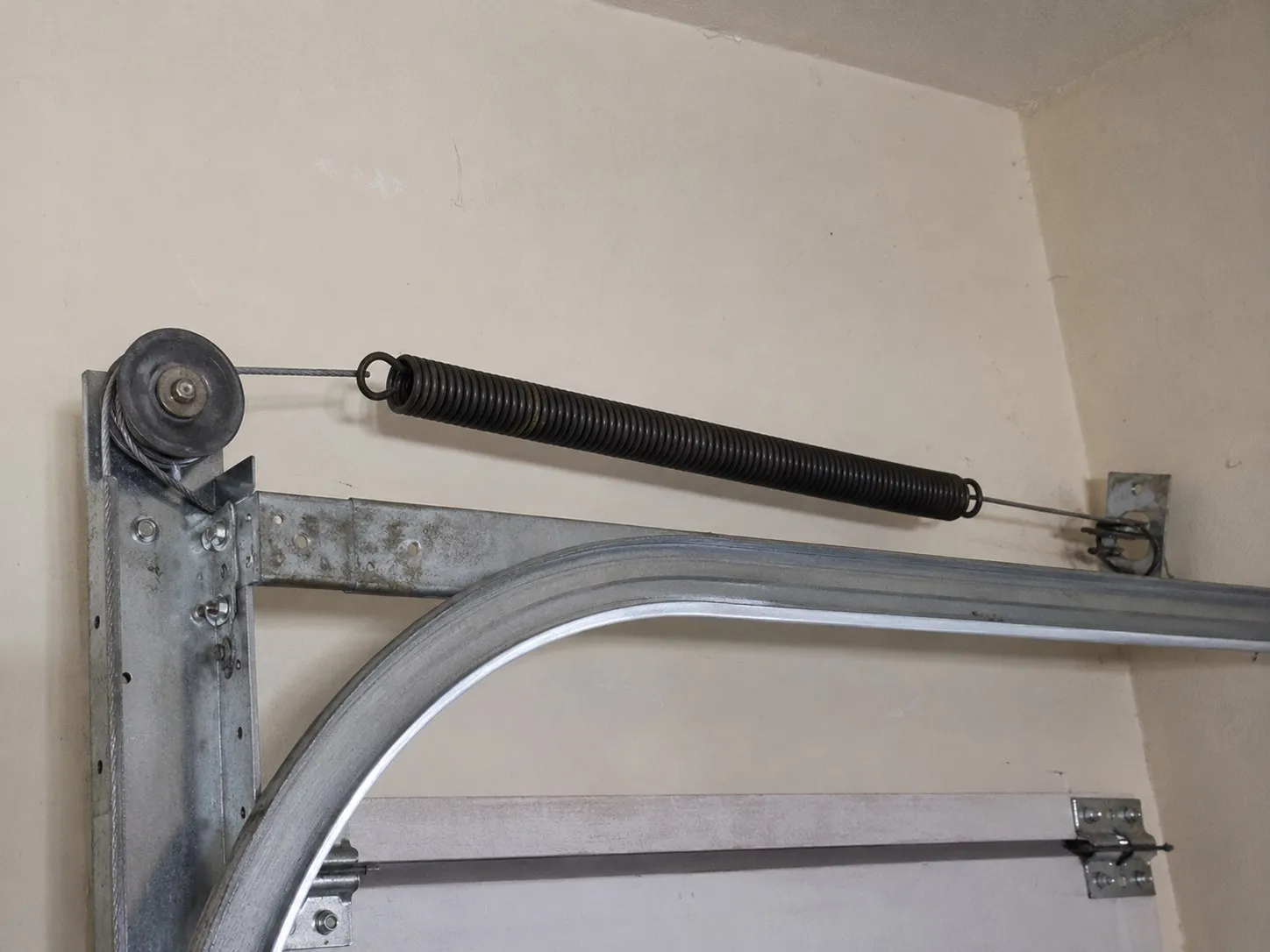Safety cable running through a garage door extension spring.